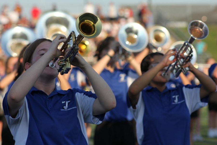 Trumpets Katelynn Hutcheson, 12th, and Caitlyn Ybarra,10th, play their pregame performance  at the Monarchs vs. Titans football game