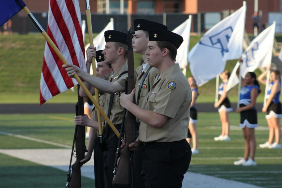 NJROTC students Matthew Bradley, 10th, Elijah Sebey, 11th, Wyatt McNeal, 11th, and Sean Leroy, 12th, perform the flag ceremony at the annual Titan-Monarch football game.