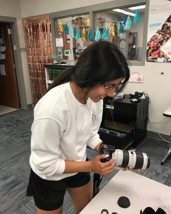 yearbook photo editor MarVella Gomez, 12th, unboxes a new camera lens