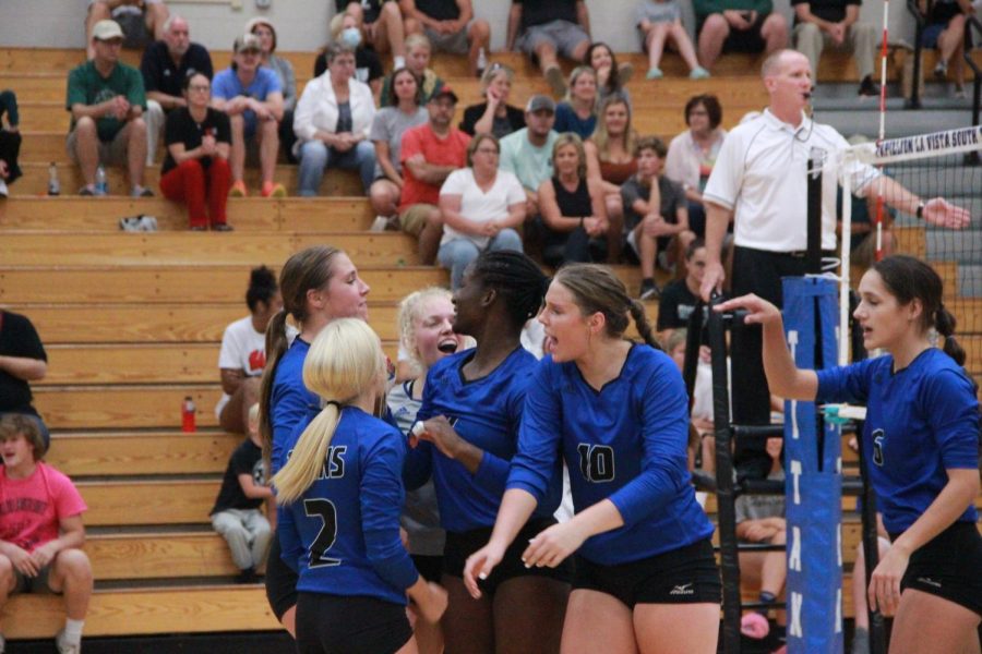 Lauren Medeck, 11th, Kyla Dyrstad, 11th, Kenzie Dyrstad, 12th, Stella Adeyemi, 12th, Charlee Solomon, 10th, and Ava Greene, 12th celebrate after scoring a point on Millard West. (Photo by Piper Holland).