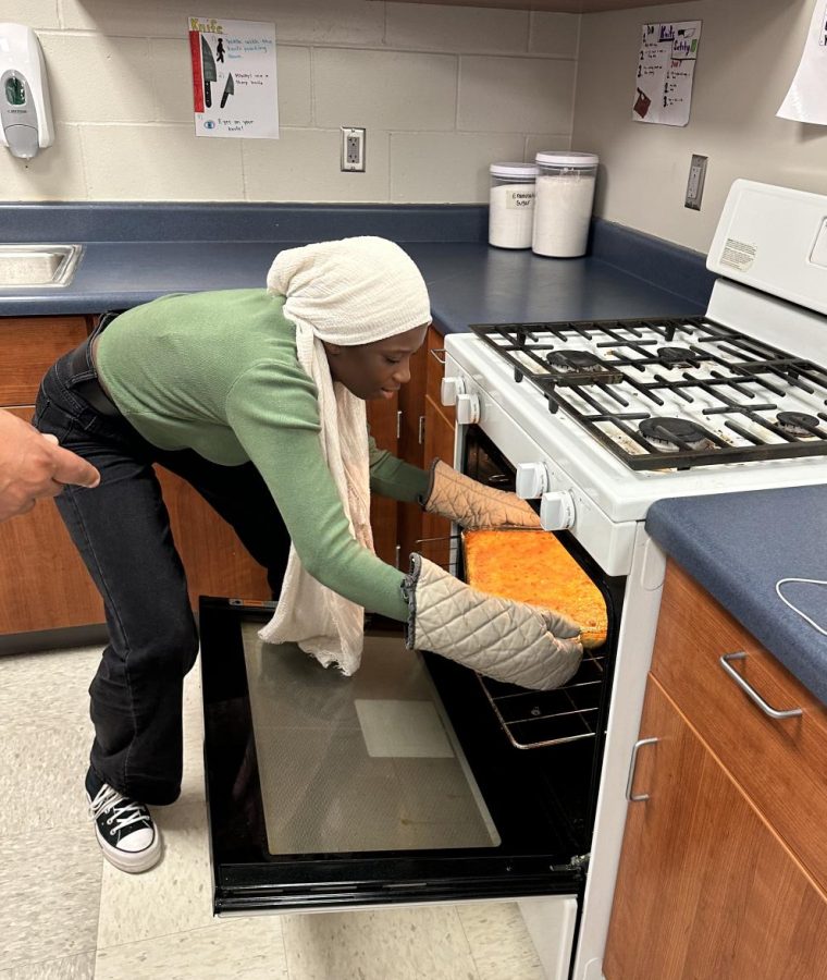 YGB member Aminta Sange, 11th, removes food from oven.