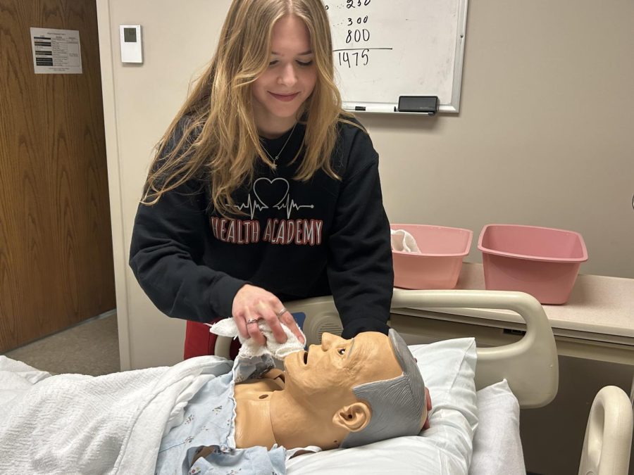 Sydney Trout, 11th, cleans a mannequins face.