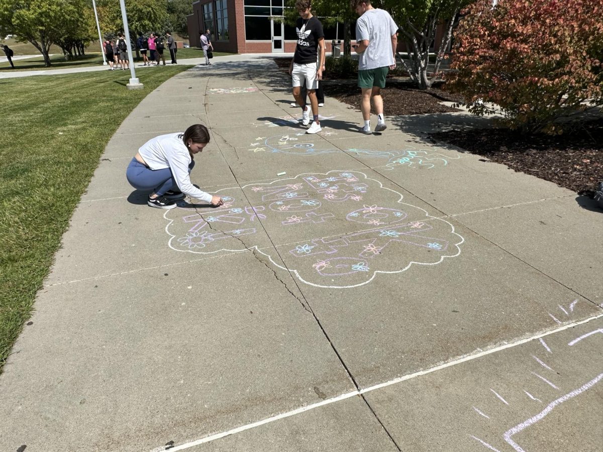 Izzy Haggard drawing message with chalk.