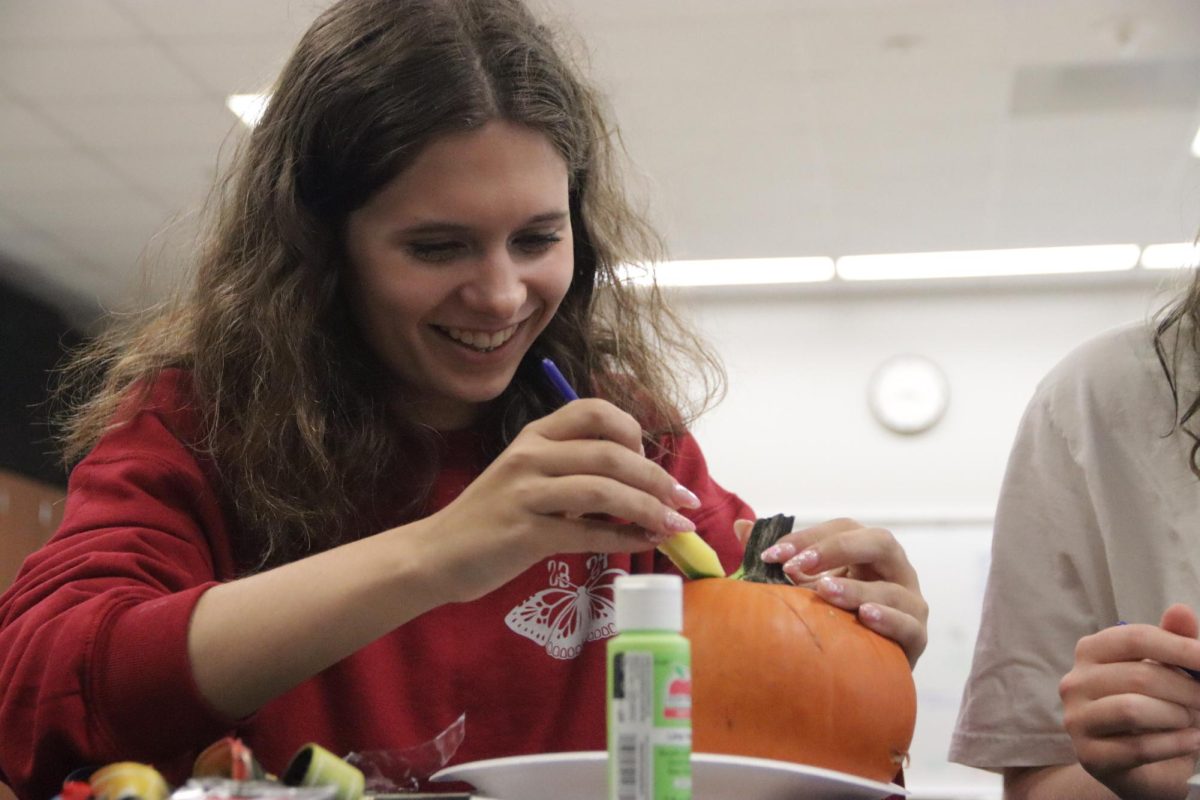 Zoe Retikis, 11th, paints her pumpkin.