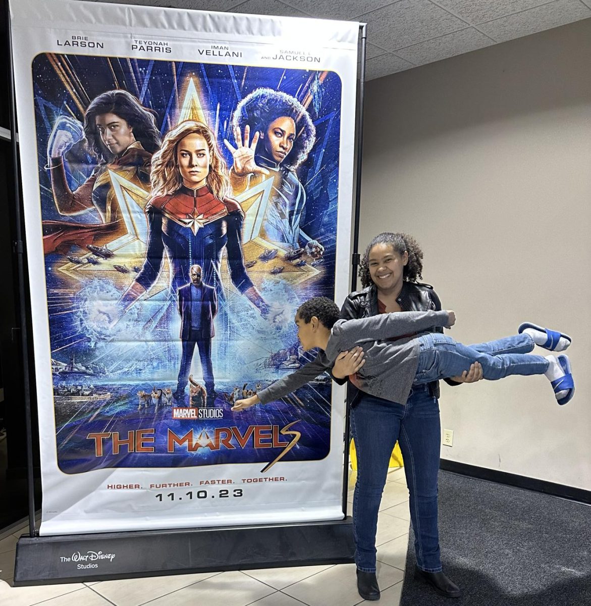 Me holding my little brother. Quincy Harris (Carriage Hill 2nd grader) as he superhero poses in front of the movie poster.