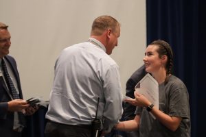 Rourke Nebel receives her 2023-24 academic letter from Assistant Principal Brent Gehring at a ceremony in Titan Theater on Aug. 27. 