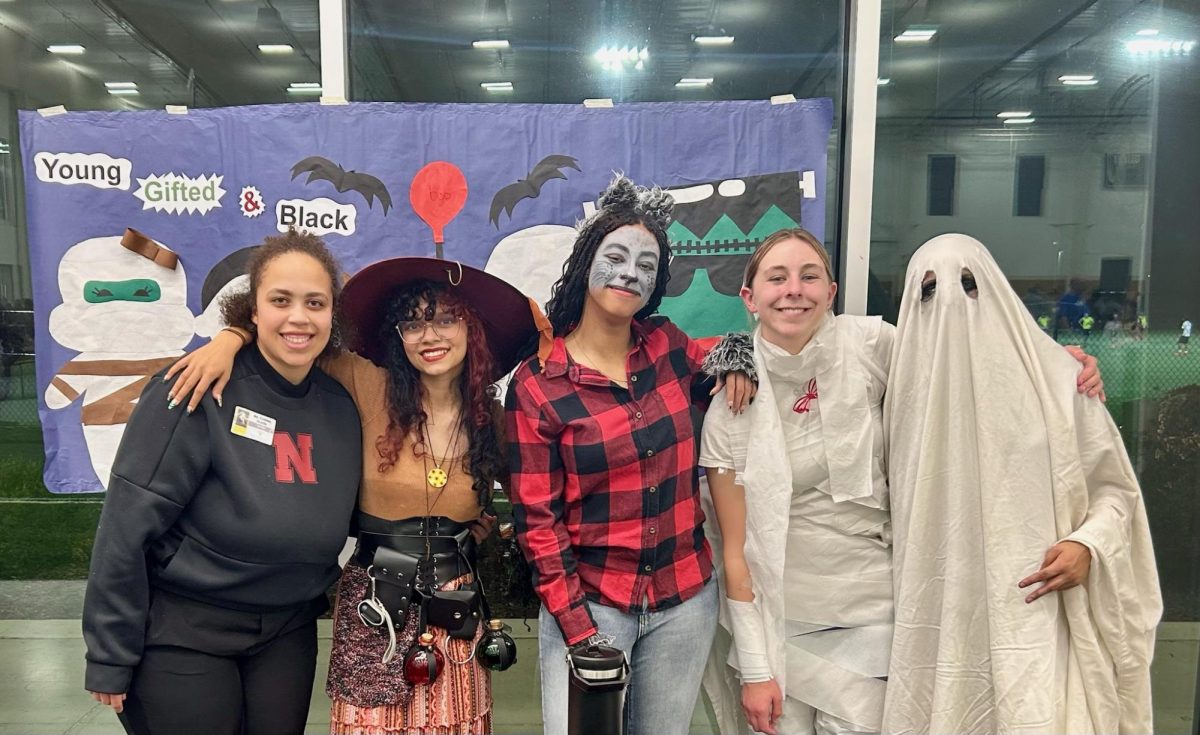 The members of Young Gifted and Black, posing in front of their poster during Halloween Safe Night.