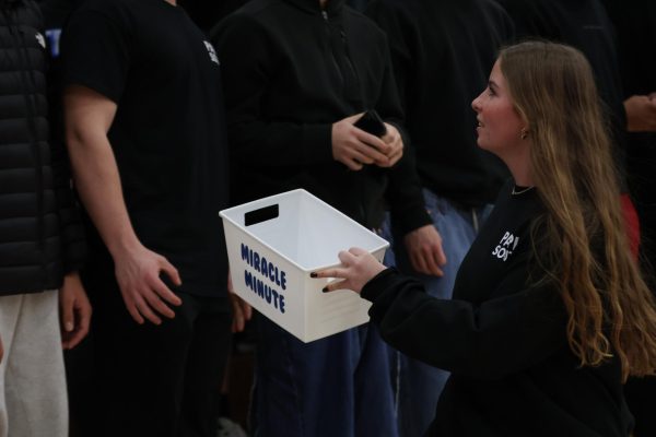 Student Council member Kinsey Lathrop collects donations at the Jan. 17 "Swishes for Wishes" win against Westside.