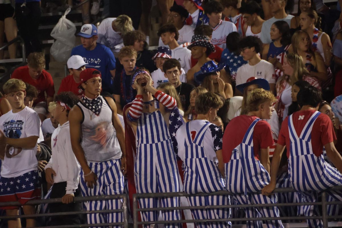 Senior Black Hole leaders Jackson Willer, Grayson Wallace, and Tyler Andringa gather in the front row of student section.