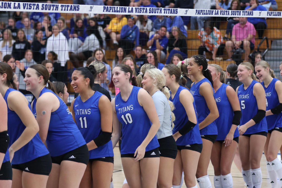 The varsity team greets Marian at the net before beating the team in three sets to one on Sept. 23.